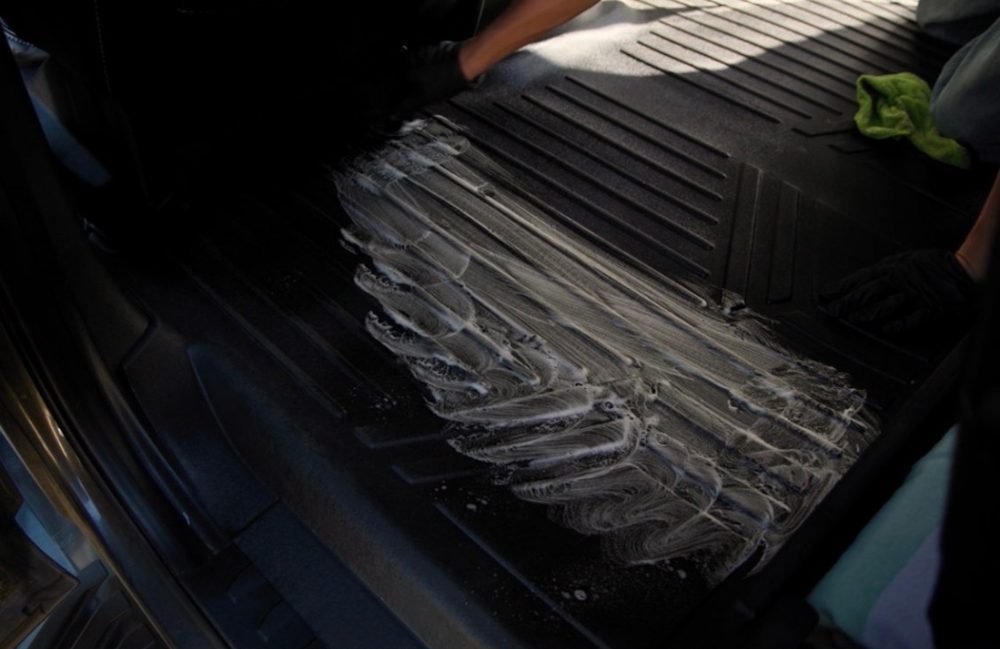 A truck's rear floor liner covered in scrubbed cleaning foam